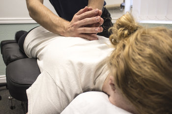 Our chiropractor providing manipulative therapy to female patient who has issues in the mid back